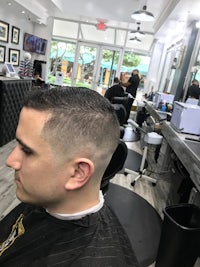 a man is getting his hair cut in a barber shop