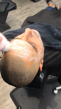 a man getting his hair cut in a barber shop