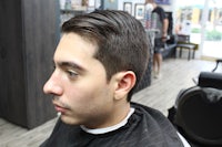 a man sitting in a barber shop with his hair cut