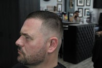 a man sitting in a barber shop with his hair cut