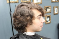 a young man getting his hair cut in a barber shop